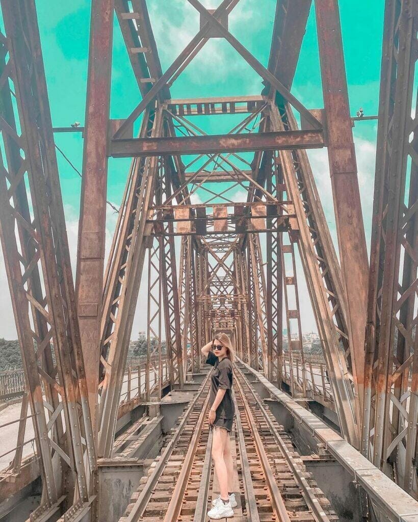 Cô gái chụp ảnh trên cầu long biên khi du lịch Hà Nội
